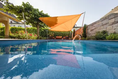 Eine gemütliche Lounge am frischen Wasser, gut geschützt durch eine hohe Steinmauer, ergänzt wird die Atmosphäre durch die im Pool integrierte Schwalldusche.  