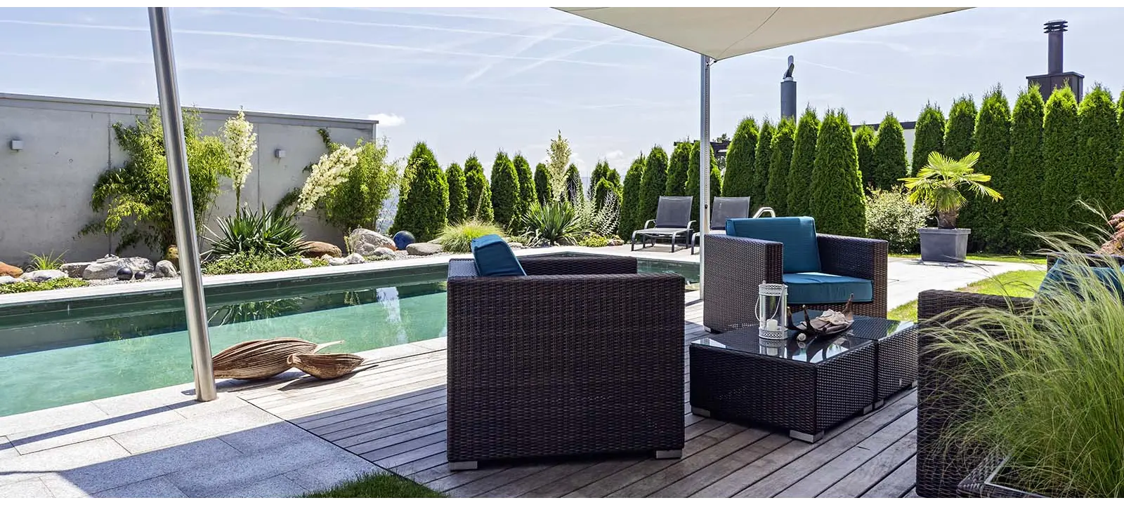 Pool mit Holzdeck und Sonnensegel